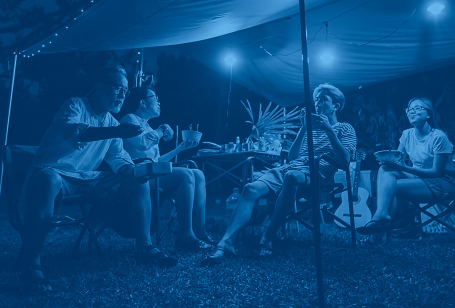 family eating outside under tent